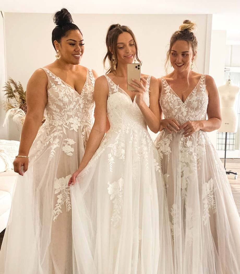 Smiling models wearing a white dresses with phone